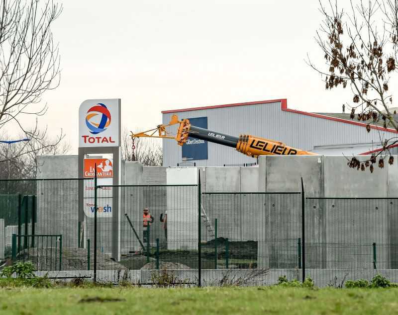 Francuzi budują wysoki mur na parkingu ciężarówek w Calais 