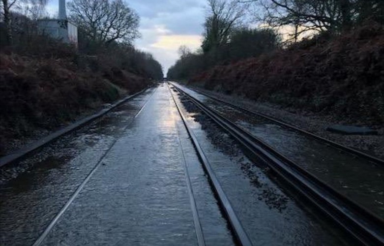 UK weather: rail lines and roads flooded after heavy rain