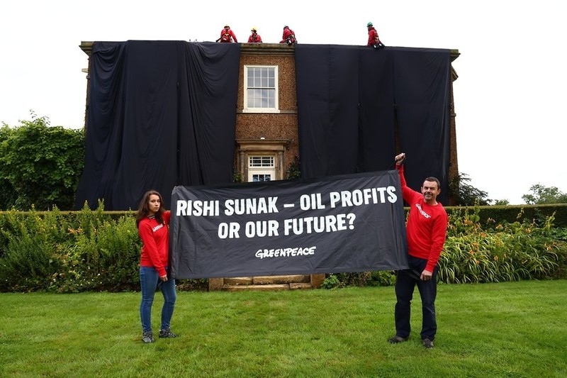 UK: Greenpeace activists draped the PM's house in oil-black fabric in protest against energy policy