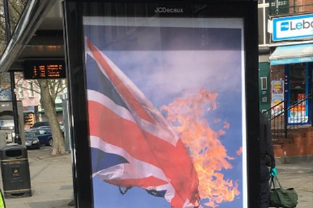 Plakaty z płonącą flagą Wielkiej Brytanii na londyńskich przystankach autobusowych