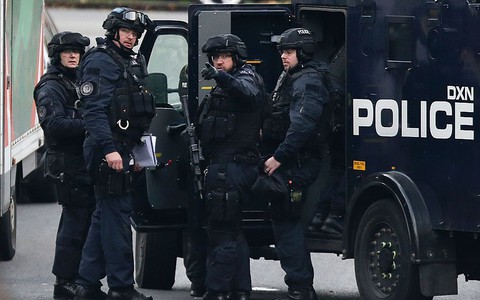 Police shoot woman in her 20s and arrest four people in terror raids